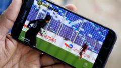 A football fan watching a live game on their phone