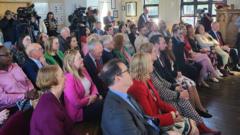 A group of Labour politicians and party members sat listening to Eluned Morgan, with Jayne Bryant, Lee Waters, Jeremy Miles and Mark Drakeford among them.