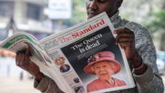 A newspaper vendor seen reading a local daily reporting on the death of Queen Elizabeth II in the city of Nairobi. Queen Elizabeth II