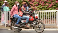 A motorcycle operator together with his client are seen wearing face masks riding in the streets as a preventive measure against the covid-19 during the pandemic. Kenya on April 7, 2020 