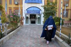 Seorang mahasiswa perempuan berjalan di depan sebuah universitas di Provinsi Kandahar, 21 Desember 2022. 