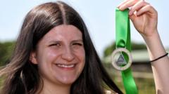 Heledd Wynn Newton yw prif gyfansoddwr Eisteddfod yr Urdd
