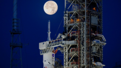Picture of nose cone of Artemis-i SLS rocket and Orion capsule on launch gantry with moon above