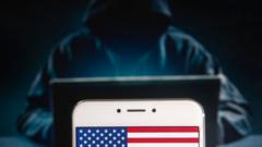 Силуэт хакера на фоне смартфона с американским флагом