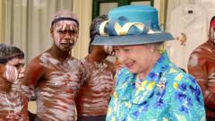 The Queen pictured walking past Aboriginal dancers