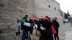 Abakerarugendo bari kwifotoreza iruhande rwa Kiliziya y'Ivuko, aho bemera ko ariho Yezu Kristu yavukiye