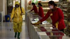 Employees spray disinfectant and wipe surfaces as part of preventative measures against the Covid-19 coronavirus at the Pyongyang Children's Department Store in Pyongyang on 18 March 2022