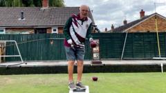 Bowler with no hands uses metal cradle to play