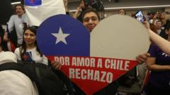 Homem com cartaz em forma de coração e as cores da bandeira do Chile onde se lê: 'Por amo ao Chile, rejeito'
