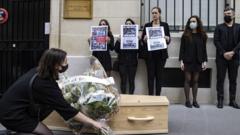 Members of RSF, Reporters Sans Frontieres (Reporters Without Borders) carry a mock coffin and pages of Hong Kong-based Apple Daily newspaper, during a protest against the closure of the newspaper, outside the Chinese Embassy in Paris, France, 25 June 2021.