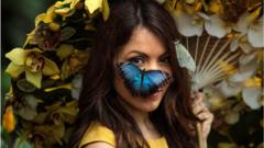 A Blue Morpho butterfly sits on the face of model Jessie Baker as she poses during a photocall at RHS Garden Wisley