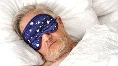 Man in bed wearing an eye mask