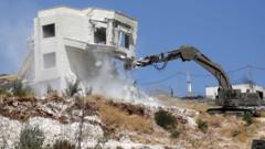 Israeli army excavator demolishes a building in Wadi Hummus, in the occupied West Bank (22 July 2019)