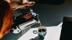 Photo of a woman pouring an espresso cup into a small mug