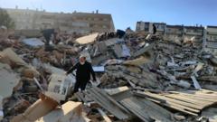 A man walks among debris of collapsed buildings after a magnitude 6.6 quake shook Turkey's Aegean Sea coast