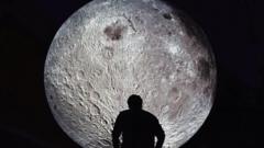 'Museum of the Moon' installation artwork by Luke Jerram. A man looking at the Moon installation