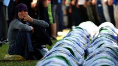Boşnak bir kadın 11 Temmuz 2019'da Srenbrenitza'da, cesetleri yeni çıkarılan 33 kişinin yanında ağlarken