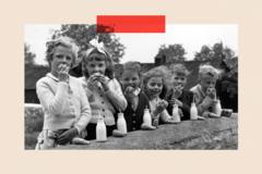 A group of children drink milk in a black-and-white image