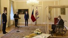 Czech President Milos Zeman, separated by a transparent wall after testing positive for the coronavirus , appoints Civic Democratic Party (ODS) leader Petr Fiala as the new prime minister.