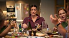 A woman sat at a dinner table with people talking around her.