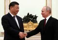 Xi (à esq.) e Putin se cumrpimentam durante encontro na Rússia