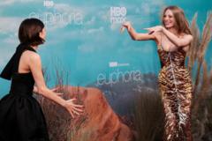 Hunter Schafer smiling and pointing with both hands at Zendaya, who has both arms as if preparing to hug Schafer