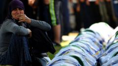 A Bosnian Muslim woman mourns by the caskets of 33 newly identified bodies of the 1995 Srebrenica massacre, on 11 July 2019