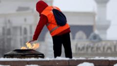 Мужчина греет руку о вечный огонь в Бишкеке