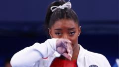 Simone Biles rubs her face during the women's team final at Tokyo 2020