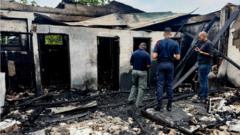 Investigators inspect a burnt-out school dormitory