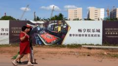 Khách du lịch Trung Quốc đi ngang qua một công trình xây dựng một sòng bài do người Trung Quốc đầu tư ở thành phố Sihanoukville, tỉnh Phreah Sihanouk.