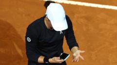 Iga Swiatek reacts to her mobile phone during a match at the Italian Open