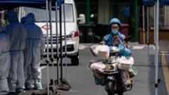 A delivery man rides a scooter trough a road blockade and a makeshift Covid-19 testing site during the city lockdown in Shanghai, China, 25 April 2022. On 25 April 2022