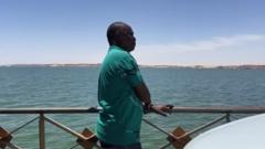 Mohamed Osman looks at the River Nile during the crossing between Sudan and Egypt