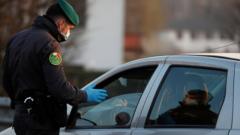 A member of the Guardia di Finanza wearing a face mask stops a car, amid a coronavirus outbreak in northern Italy