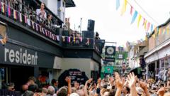 Singer Nick Cave plays a show with his band on the roof of a record shop in Brighton. The street below is swamped with fans.