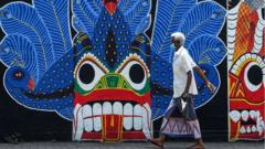 A man wearing a facemask walks past a mural during a government-imposed nationwide lockdown as a preventive measure against the COVID-19 coronavirus, in Colombo on April 3, 2020.