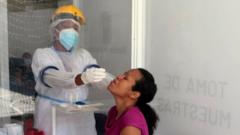 A health worker takes a COVID-19 test sample on a woman on November 3, 2020 in Medellin, Colombia.