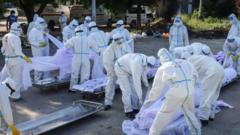 Volunteers wearing personal protective equipment (PPE) arrange bodies of people who died from the Covid-19 coronavirus during their funeral at a cemetery in Mandalay on July 14, 2021.