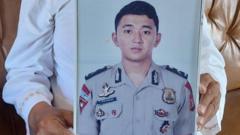 Foto Brigpol Setyo Herlambang dipegang oleh ayahnya, Sabtu (23/09).