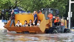 Rescue workers evacuate stranded residents with a bulldozer on a flooded street on 11 August after typhoon Lekima hit Taizhou, Zhejiang province.