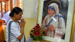 A woman prays in front of a picture of Mother Teresa in India