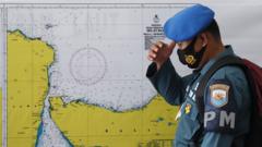 A military officer stands in front of a map of the search area for the missing Indonesian Navy submarine KRI Nanggala, at a command in Ngurah Rai Airport in Bali, Indonesia, 23 April 2021