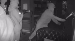 Video shows men armed with axe breaking into pub