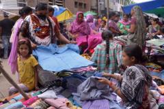 Indian customers browse through used summer clothes at a roadside stall in Amritsar on July 12, 2015. Second-hand summer clothing is in heavy demand. AFP PHOTO/ NARINDER NANU (Photo credit should read NARINDER NANU/AFP via Getty Images)