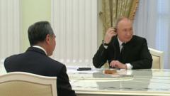 President Putin sits opposite Wang Yi