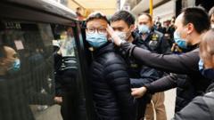 香港觀塘《立場新聞》辦公室所在大樓外警察國安處探員將《立場新聞》署理總編輯林紹桐押上車（29/12/2021）