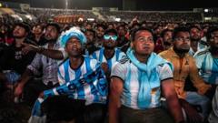 Qatar's migrant workers watch the match Argentine vs Mexico at a stadium in the Asian Town shopping complex
