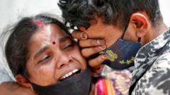 A woman mourns with her son after her husband died due to the coronavirus disease (COVID-19) outside a mortuary of a COVID-19 hospital in Ahmedabad, India, April 20, 2021.