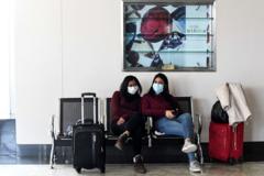 Passengers wearing protective facemasks wait at Bandaranaike International airport in Katunayake on January 30, 2020. - 